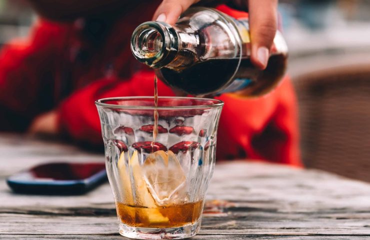 Refreshing glass of cola on wooden table in a bar