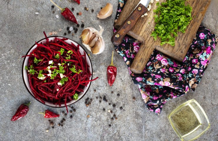 Beetroot salad with oil and nuts in white bowl. Selective focus.