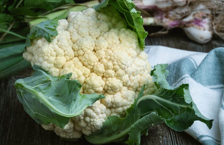 Large cauliflower head on a wooden table.