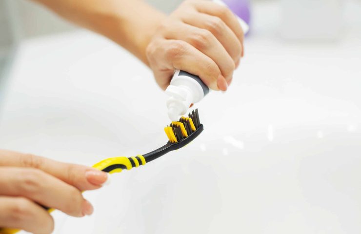 Close up hands woman use toothbrush in light bathroom
