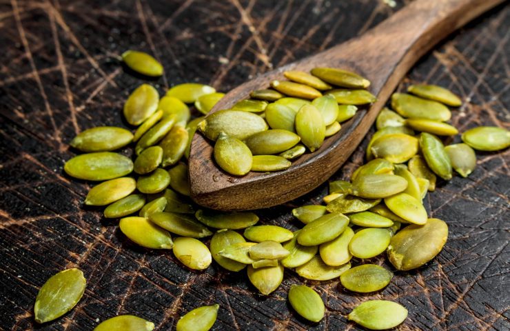 Pumpkin seeds in a spoon.
